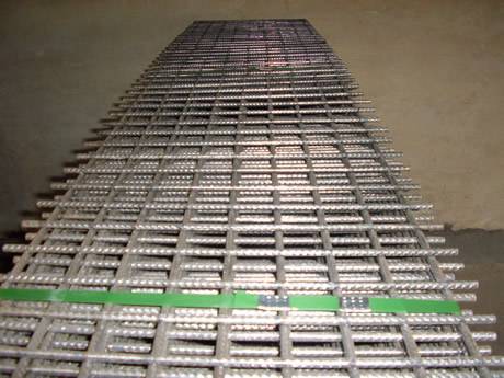Many rectangular sheets of reinforcement welded mesh are packed with green baling strip.