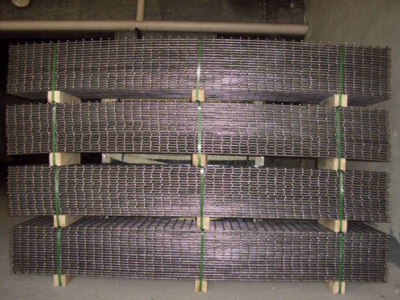 Many sheets of reinforcing mesh are placed together and there are many wooden supports under the mesh at regular intervals.