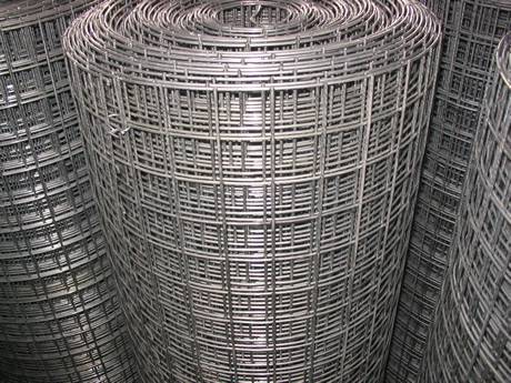 Rolls of reinforcing welded meshes are placed on the ground.